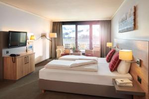 贝阿滕贝格贝阿滕贝格/因特拉肯多里安布吕姆利斯山酒店的酒店客房设有一张大床和一台电视。