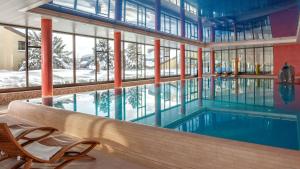 贝阿滕贝格贝阿滕贝格/因特拉肯多里安布吕姆利斯山酒店的一座带大窗户的建筑中的游泳池