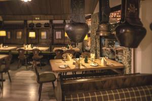 贝阿滕贝格贝阿滕贝格/因特拉肯多里安布吕姆利斯山酒店的餐厅设有木桌和椅子及灯