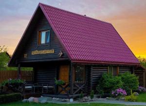 维尔纽斯Trijų žvaigždučių palapinė Vilniuje的小木屋设有紫色屋顶和房屋