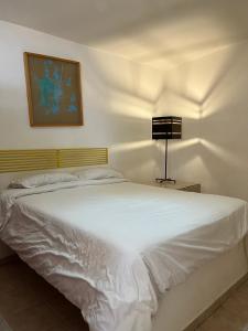 圣路易斯波托西INMOTEGA - Suites TG的卧室配有白色的床和灯