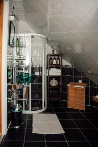 奥勒松Panorama Apartment Ålesund的浴室设有玻璃淋浴间和黑色瓷砖