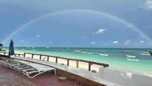 南威Blue Tides Hotel的海滩上的彩虹,海滩上设有长凳和码头