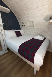 布罗拉North Coast 500 Pods - Brora的卧室配有一张带铺着地毯的白色床
