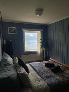 GrimoFjord House的一间卧室设有一张大床和窗户