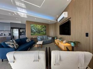 瓜鲁雅Condomínio Costa Esmeralda的一间带蓝色沙发的客厅和一间厨房