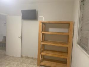 索莱马Lindo Apartamento Pé na Areia Canto do Forte的木书架,有门的房间