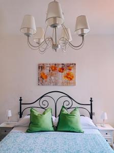 圣吉米纳诺Affittacamere Chiti Melania的一间卧室配有一张带两个绿色枕头的床