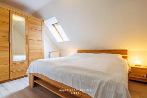 拉博埃Kapitänshaus Fewo Seemann Budle的卧室配有一张白色的大床和天窗。