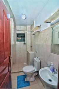 内罗毕Magazi suites 3的浴室配有白色卫生间和盥洗盆。