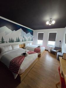 怀特霍斯Raven Inn Whitehorse的一间带两张床的卧室和山壁画