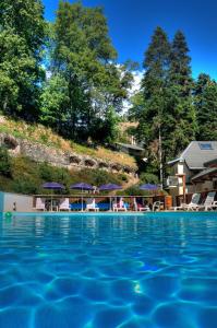 布里德莱班小屋酒店的度假村内带椅子和遮阳伞的游泳池