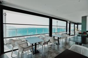 伏罗拉Grand Mirage的一间设有桌椅的海洋餐厅