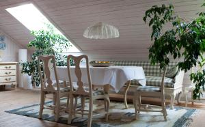 图什比萨尔斯特姆斯加登酒店的一间配备有白色桌椅的用餐室
