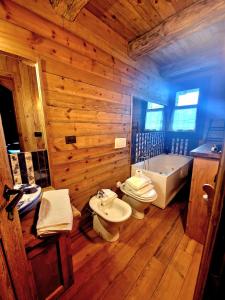 圣贾科莫Chalet Euthalia Restaurant & Suites的木制浴室设有2个卫生间和浴缸