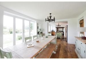 阿默舍姆Charming 5BR Farmhouse Retreat in Amersham的一间带木桌和椅子的用餐室