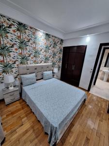 卡萨布兰卡Morocco House的一间卧室设有一张大床和花卉墙