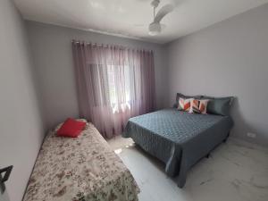 大普拉亚BEIRA MAR I - TUPI - 15 metros da praia - 2 dormitórios com VARANDA - WI FI e acomoda até 8 pessoas - ESTACIONAMENTO Gratuito的一间卧室设有两张床和窗户。