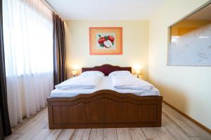 莱布尼茨Hotel Vulkan Residenz - Self-Check-in的卧室内的一张床位,两盏灯