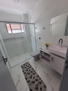 大普拉亚BEIRA MAR I - TUPI - 15 metros da praia - 2 dormitórios com VARANDA - WI FI e acomoda até 8 pessoas - ESTACIONAMENTO Gratuito的一间带水槽、卫生间和镜子的浴室
