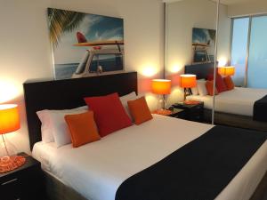 凯恩斯Cairns Private Apartments的一间卧室配有一张带橙色枕头的大床