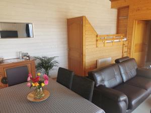 勒孔凯Proche Pointe Saint Mathieu et plages, avec piscine chauffée dans résidence的客厅配有一张桌子、一张沙发和一张桌子。