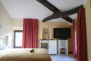 波雷塔泰尔梅Hotel Italia的一间卧室配有一张床和一台平面电视