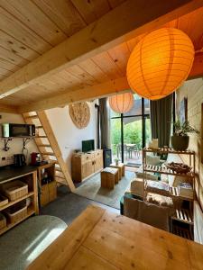 贝克贝亨Tiny House met Hottub op de Veluwe的客厅设有木制天花板和桌子