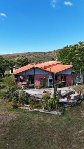 卡兰卡斯Sítio Mata Virgem的田野上一座带橙色屋顶的房子