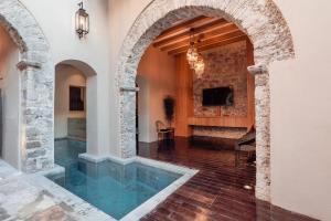 圣米格尔-德阿连德Le Cottage San Miguel de Allende, Modern Luxury in Centro with Pool & Jacuzzi的一座带拱门的室内泳池