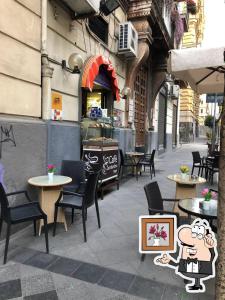 那不勒斯Suite Ottocento napoletano的一个带桌椅的庭院和一间餐厅