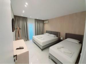 卡萨米尔GB Rooms的酒店客房配有两张床和一张书桌