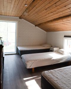 ByskeLovely cabin with a beautiful view over Byske river的客房设有三张床和大窗户