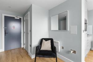 切姆Luxurious One Bedroom Apartment in Bond Street的一间设有黑椅子和镜子的客房