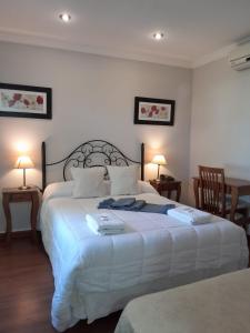 胡宁Hotel Azul Junin的一间卧室配有一张带两盏灯的大型白色床。