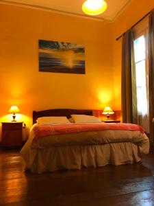 瓦尔帕莱索B&B La Nona的一间卧室配有一张黄色墙壁的床和两盏灯。
