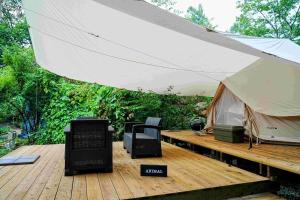 安昙野市Glamping Azumino BASE Polecan - Vacation STAY 49297v的木甲板上的一个帐篷