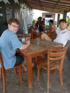 尼甘布Negombo Royal Villa by Hotel Oviniru的坐在木桌旁的一群人
