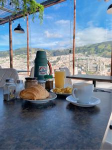 基多Hostal La Terraza的一张桌子,上面放着一盘面包和一杯咖啡