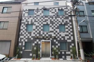 东京MARUKOU HOTEL的上面有校对板图案的建筑