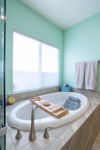 埃尔卡洪Modern Paradise of East County-4BR-Jacuzzi的带浴缸的浴室和窗户