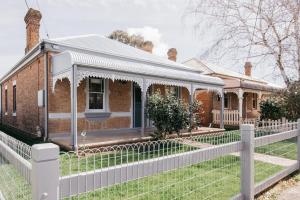 奥兰治Dimby Cottage Beautifully Restored Heritage Home的前面有白色围栏的砖房