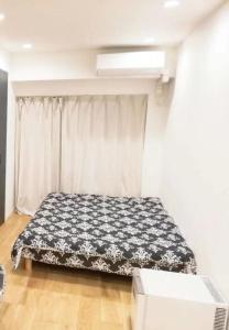 东京Shibuya Hana House的一间卧室配有一张带黑白毯子的床