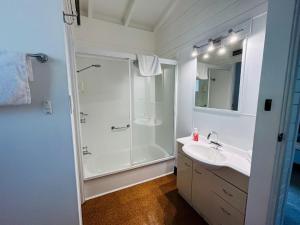 比舍诺比切诺海湾酒店的带淋浴和盥洗盆的白色浴室
