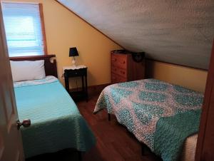桑威奇Oldest Town of Cape Cod In The Historic District的一间卧室设有两张床、一个梳妆台和窗户。