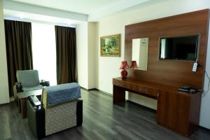 巴库AEF Hotel and Restaurants的酒店客房配有书桌、电视和椅子。