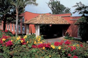 贾拉普哈拉帕嘉年华酒店的一座建筑前面有鲜花花园