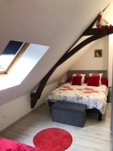 MontpollinUn coin de paradis的阁楼卧室配有床和红色地毯