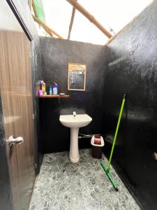 埃拉Backpackers Hostel的浴室设有白色水槽和黑色墙壁