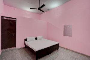 诺伊达OYO Hotel star palace的卧室配有一张粉红色墙壁上的床铺